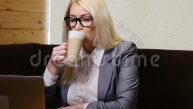 女商人手提电脑，在咖啡馆喝咖啡